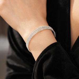 Close-up of triple-row silver tennis bracelet with sparkling diamonds on female wrist