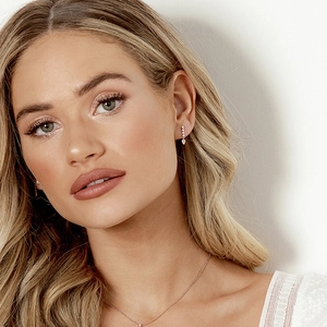 Close-up of minimalist rose gold teardrop earrings and necklace set with zircon on model