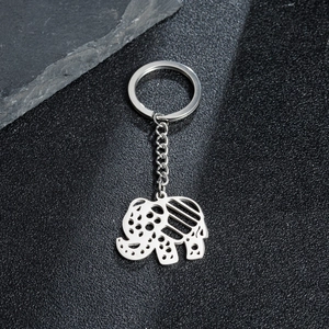 Macro shot of mirror-polished elephant keychain with hollow patterns on black texture