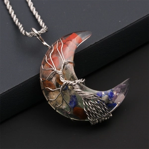 Macro detail of crescent moon pendant with colorful stones and wire-wrapped tree of life