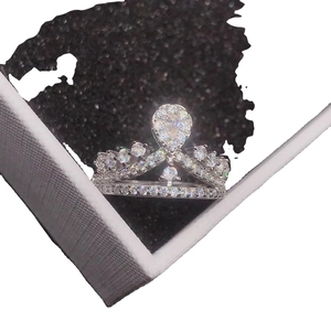 Silver crown shaped ring with sparkling clear stones presented in a dark jewelry box