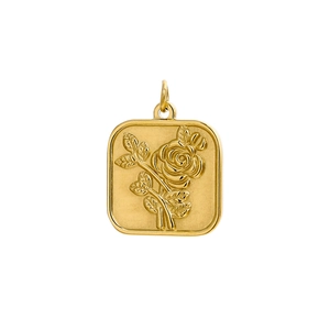 Macro detail of golden rose flower relief on square stainless steel pendant with gloss