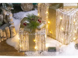 Close-up of glowing Christmas gift box with pine cones and gold ribbon decoration