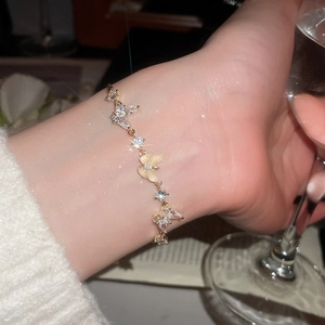 Detailed close-up of a gold-plated butterfly bracelet with zircon and cat-eye stones