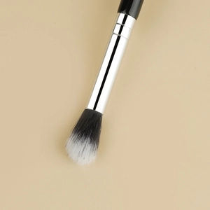 Detail of dual-tone synthetic bristles and silver metal ferrule on professional makeup brush