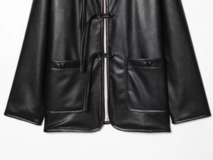 Detail of black faux leather jacket with traditional Chinese frog button closures