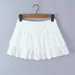 Detail of white tiered mini skirt featuring embroidery lace and side tie-up waist design