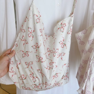 Gros plan du motif nœud floral sur le sac fourre-tout en coton blanc à texture douce