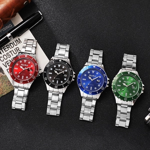 Detailed view of four quartz dive watches with colorful bezels and steel bands on a black surface