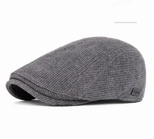 Gros plan détaillé du béret gris à texture gaufrée avec petit logo sur le côté