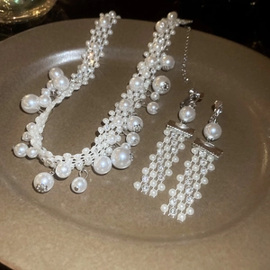 Macro shot of French vintage jewelry set with pearls and crystals on a matte tray