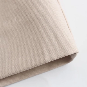 Vue macro détaillée montrant la texture du tissu en toile beige et la matière tissée
