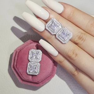 Macro view of square halo stud earrings with cubic zirconia in a pink velvet jewelry box
