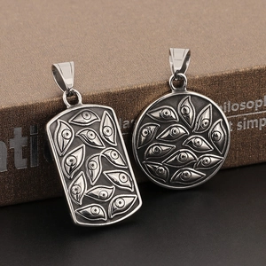 Macro view of vintage stainless steel rectangular and round Eye of Providence pendants