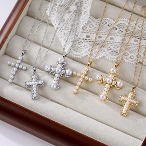 Detailed collection of vintage cross necklaces with pearls and zircon in a jewelry box
