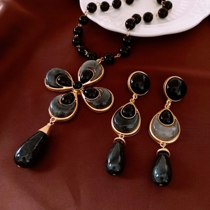 Vintage gold and black beaded jewelry set featuring cross floral pendant and water drop earrings