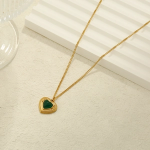Vintage gold-plated stainless steel necklace with a green heart pendant on a textured base