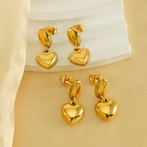 Textured and polished 18K gold-plated heart stud earrings on elegant silk background