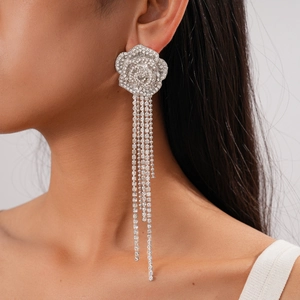 Close-up of sparkling silver floral tassel earrings with rhinestones worn by a model