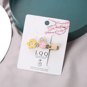 Japanese style gold hair clip with pink enamel cat, yellow flower, and sparkling crystals