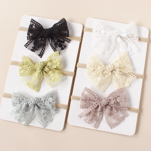 Detail view of handmade lace bow headbands in six pastel colors on display cards