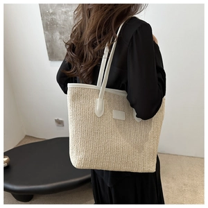 Vue détaillée du dos d'un grand sac cabas en paille tressée avec anses en cuir blanc