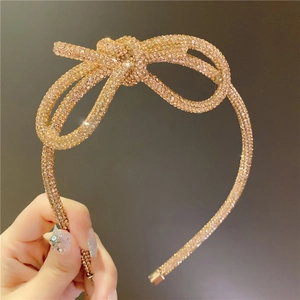 Close-up of elegant rose gold headband with intricate sparkling rhinestone bow detail