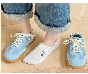 Close-up of white invisible socks featuring cute bear embroidery and retro blue sneakers