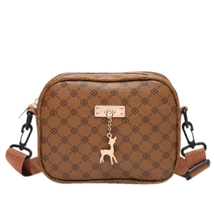 Retro brown monogram crossbody bag with a metal deer pendant on a white background