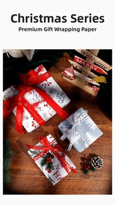 Close-up of Christmas wrapping paper with berry and pine patterns and festive ribbons