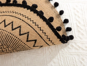 Close-up of jute placemat texture with black geometric patterns and fringe