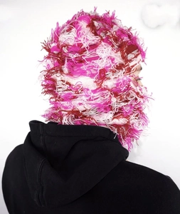 Rear view of pink and white distressed knit balaclava with long fringe and frayed edges