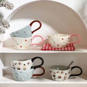 Close-up of ceramic mugs with large round handles and cute animal patterns on a white shelf