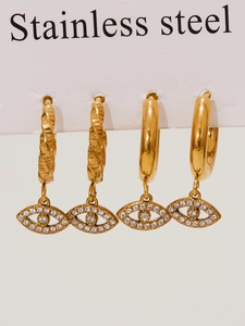 Detailed macro view of gold-plated evil eye earrings with zircons and polished finish