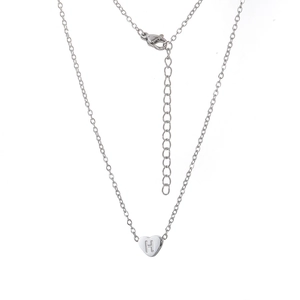 Détail du pendentif en cœur argenté avec lettre H gravée et chaîne en acier inoxydable