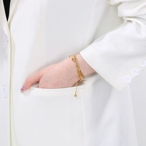 Minimalist double layered gold chain bracelet set for women worn on wrist with white blazer