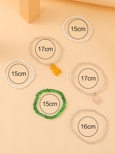 Detailed view of 6-piece beaded bracelet set featuring resin bear and flower charms