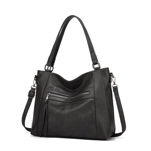 Detail of black soft PU leather handbag with front zipper pocket and tassel puller