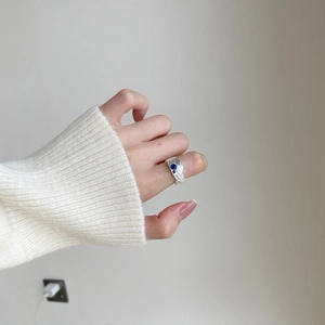 Irregular textured S925 sterling silver ring with blue gems on a model hand