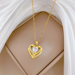 Gold heart necklace with crystals and I LOVE YOU engraving on a beige jewelry box