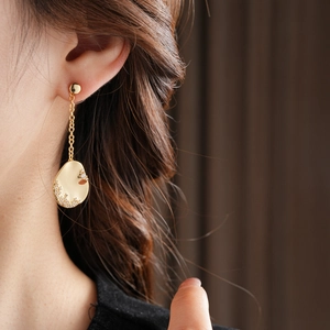 Détail d'une boucle d'oreille goutte en or 18k avec abeille et cristaux sur mannequin