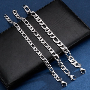 Three silver stainless steel Figaro chains in different widths on a black leather wallet