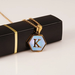 Detail of 18K gold stainless steel necklace with blue shell hexagon pendant letter K