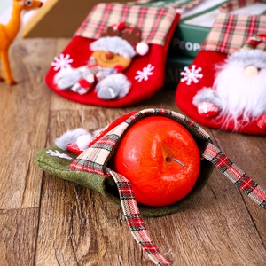 Close-up of a green plaid Christmas candy bag with ribbon on a rustic wooden table