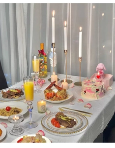 Romantic dinner scene with elegant gold candle holder and luxury tableware on white cloth
