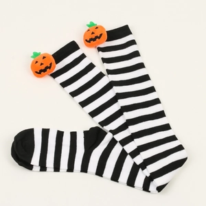 Detail of Halloween over-knee socks featuring black white stripes and plush pumpkins