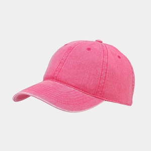 Détail de la casquette rose délavée montrant la texture vintage et le bord usé