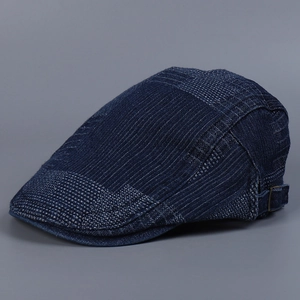 Detailed side view of a vintage blue denim ivy cap with irregular grid pattern texture