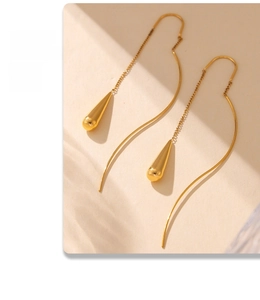 Detail shot of elegant golden tassel drop earrings with sleek chain and waterdrop pendant