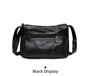 Vue détaillée du sac bandoulière noir avec fermetures éclair et texture grainée